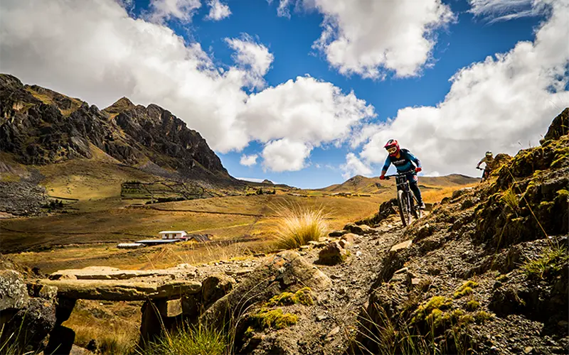 Biker crossing rocky high-altitude pass in Lamay (Peru Biking Tours)